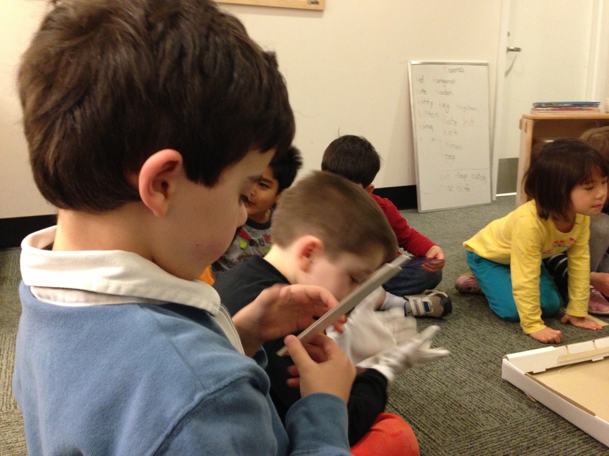 Children examining drawing instruments at SEEC.